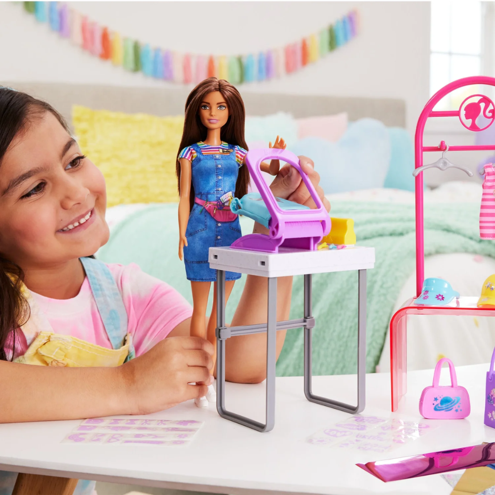 Barbie Make & Sell Boutique Playset with Brunette Doll, Foil Design Tools, Clothes & Accessories. Kids can stitch their way into the fashion world with the Barbie Make & Sell Boutique playset! HKT78 thumbnail
